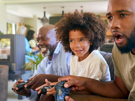 Multi-Generation Male Family Having Fun Playing Computer Game Sitting On Sofa At Homeの写真素材