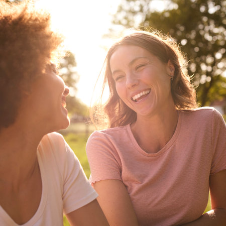 Two Female Friends Or Same Sex Couple Leaning On Fence On Walk In Countryside Togetherの写真素材