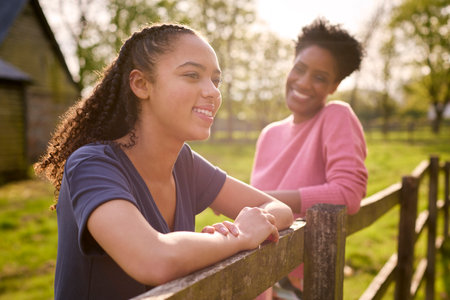 Mature Mother With Teenage Daughter Enjoying Walk In Countryside Togetherの写真素材