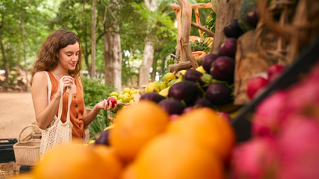Female Customer At Market Stall Choosing Fresh Fruit And Vegetablesの写真素材