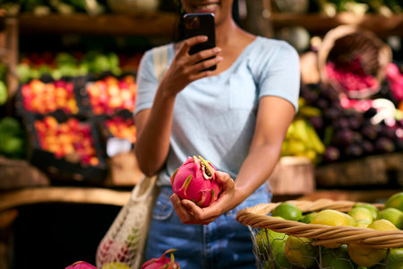 Close Up Of Female Customer At Market Stall Taking Photo Of Fresh Dragon Fruit On Mobile Phoneの写真素材