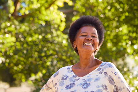 Portrait Of Smiling Senior Woman Standing Outdoors In Garden Park Or Countrysideの写真素材
