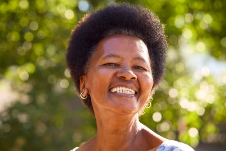 Portrait Of Smiling Senior Woman Standing Outdoors In Garden Park Or Countrysideの写真素材