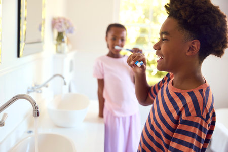 Brother And Sister In Bathroom At Home Brushing Teeth Togetherの写真素材
