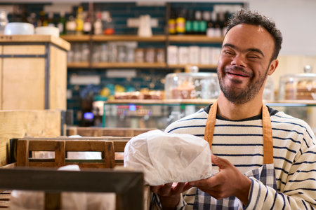 Smiling Man With Down Syndrome Stocking Shelf With Bread In Food Shop