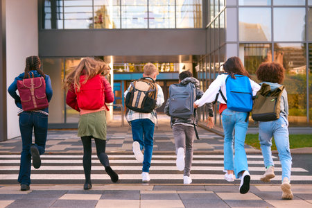 Group Of Secondary Or High School Pupils Running Away From Camera Outside School Buildingの写真素材