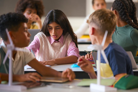 Secondary Or High School Students Studying Wind Turbines In Science Class With Teacher In Backgroundの写真素材
