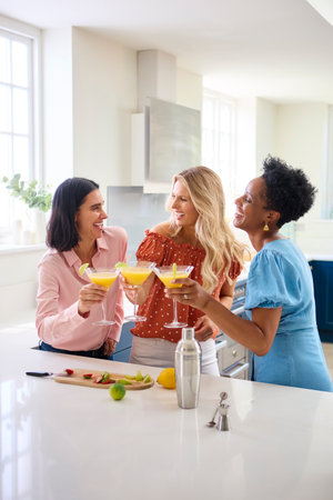 Three Mature Female Friends At Home Celebrating With Cocktails Togetherの写真素材