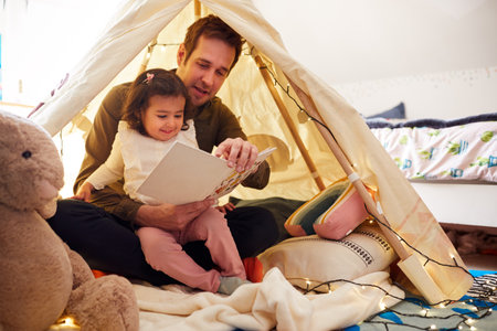 Single Father Reading With Daughter In Den In Bedroom At Homeの写真素材
