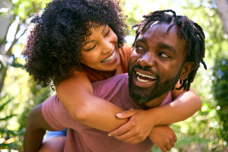 Loving Mid Adult Couple Outdoors In Summer Garden Or Countryside With Man Giving Woman Piggybackの写真素材