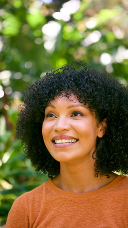 Head And Shoulders Portrait Of Smiling Confident Mid Adult Woman Standing Outdoors