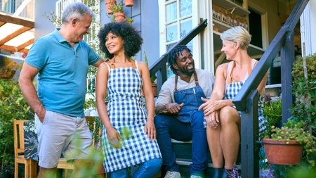 Portrait Of Smiling Staff And Management Team On Steps Outside Cafe Or Shop In Garden Centreの写真素材
