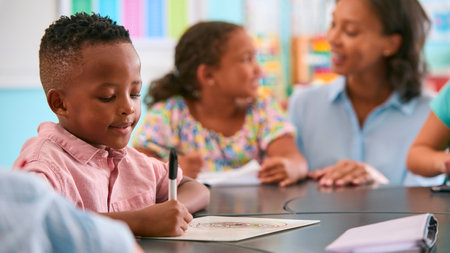 Male Primary Or Elementary School Student At Desk In Classroomの写真素材