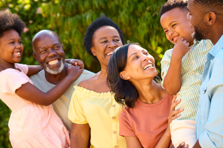 Portrait Of Laughing Three Generation Family Outdoors In Summer Countryside Or Garden