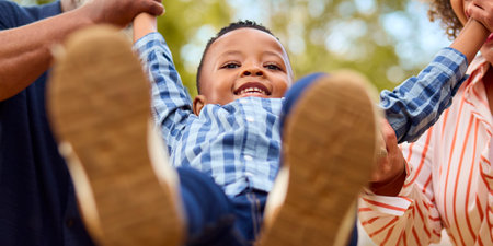 Close Up Of Grandparents Swinging Grandson Outdoors In Countryside Or Gardenの写真素材