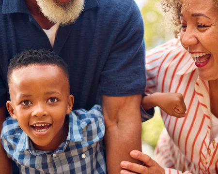 Close Up Of Loving Grandparents Hugging Grandson Outdoors In Countryside Or Gardenの写真素材