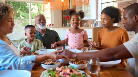 Multi-Generation Family Saying Prayer Before Eating Meal At Home Togetherの写真素材