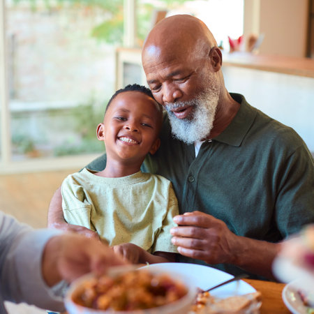 Multi-Generation Family Around Table Serving And Eating Meal At Home Togetherの写真素材