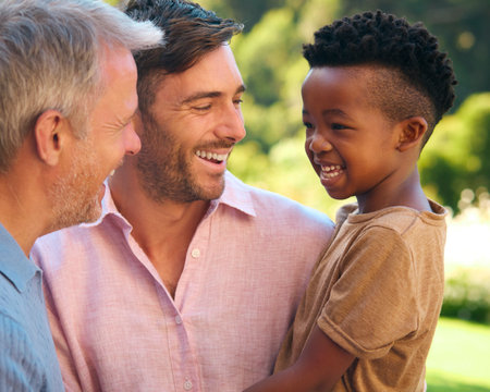 Portrait Of Three Generation Male Family Laughing And Smiling Standing Outdoors In Countrysideの写真素材