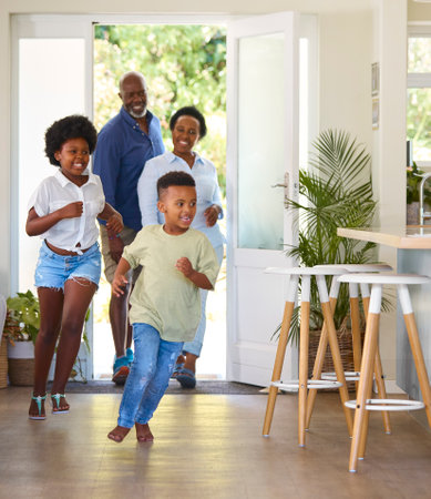 Grandparents With Grandchildren Returning Home With Children Running Ahead