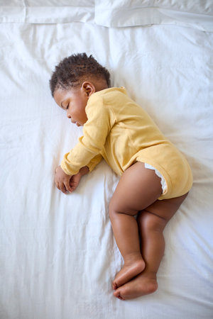 Close Up Of Sleeping Baby Girl Lying On Parent's Bed At Homeの写真素材