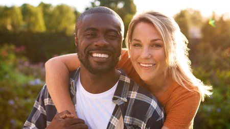 Portrait Of Loving Couple Hugging Outdoors In Countryside Together With Lens Flareの写真素材