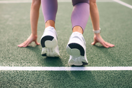 Close Up Of Female Athlete With Feet On Starting Line Before Start Of Race