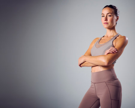 Studio Portrait Of Woman Wearing Gym Fitness Clothing Exercising On Grey Backgroundの写真素材