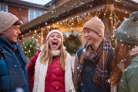 Group Of Smiling Teenage Girls And Boys Outdoors Dressed For Winter In Snow