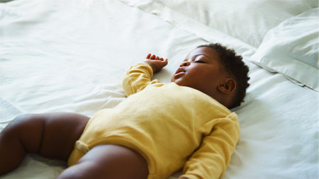 Young child peacefully resting on a bed with a relaxed expression.の写真素材