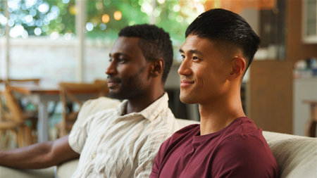 Same sex male couple or friends share a joyful moment in a comfortable living space.