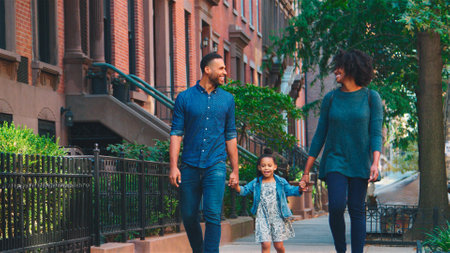 Family Shot With Parents Holding Hands With Daughter As They Walk Along Street In New York Cityの写真素材