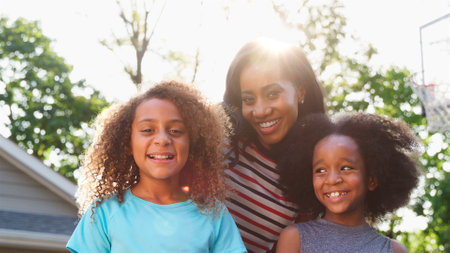 Portrait Of Smiling Mother And Children On Driveway At Homeの写真素材
