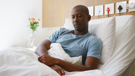 Young Male Patient Lying In Private Hospital Bedの写真素材