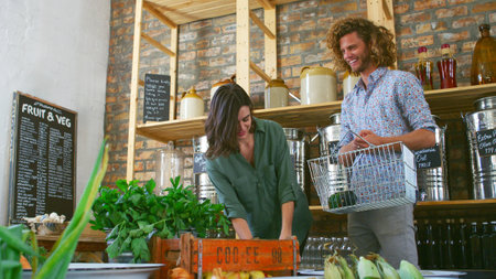 Young Couple Buying Fresh Fruit And Vegetables In Sustainable Plastic Free Grocery Storeの写真素材