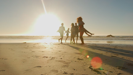 Group Of Casually Dressed Friends Having Fun On Summer Beach Together With Lens Flareの写真素材