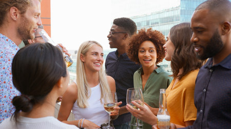 Multi-Cultural Business Team Meeting Outdoors For After Work Drinks On Office Rooftop Or Barの写真素材