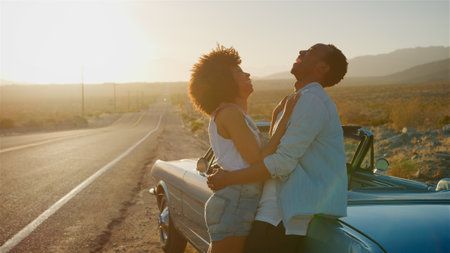 Loving Couple Next To Classic Open Top Car On Road Trip Through Countryside At Sunsetの写真素材