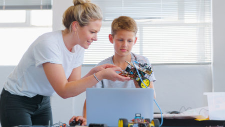 Male Student With Teacher With Laptop Building Robot Vehicle In School Computer Coding Classの写真素材