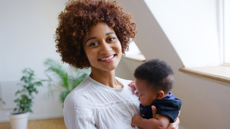 Close Up Portrait Of Loving Mother Holding Newborn Baby Son At Home In Loft Apartmentの写真素材