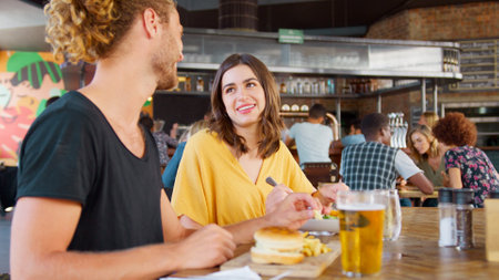 Young Couple On Date Meeting For Drinks And Food In Bar Or Restaurantの写真素材
