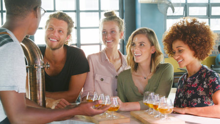 Male Server With Group Of Young Friends At Beer Tasting In Barの写真素材