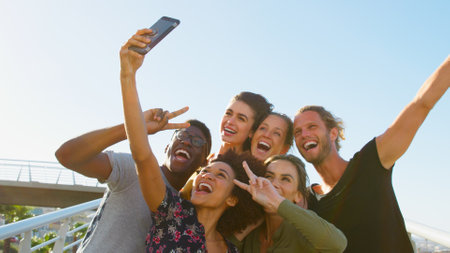 Group Of Smiling Young Friends Posing For Selfie On Outdoor Footbridge Togetherの写真素材