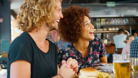 Young Couple On Date Meeting For Drinks And Food In Bar Or Restaurantの写真素材