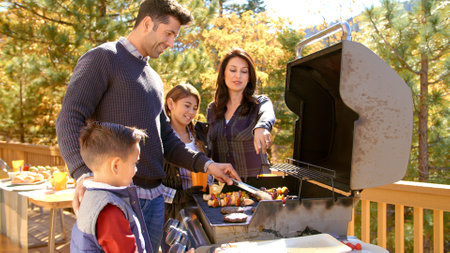 Family Outdoors At Home Enjoying Autumn Or Fall Barbecue Togetherの写真素材