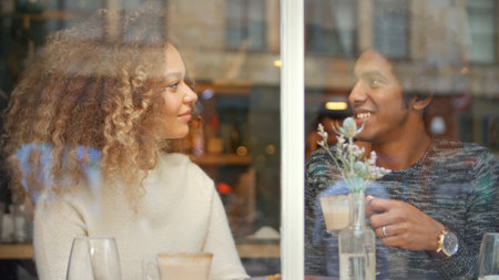 View Through Window Of Couple Meeting Sitting In Cafe With Coffeeの写真素材