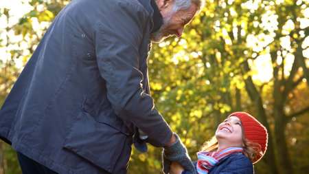Close Up Of Loving Grandfather Holding Hands With Granddaughter On Autumn Walk Through Countrysideの写真素材