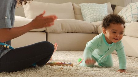 Mother And Baby Son Playing Music On Toy Xylophone Sitting On Floor At Home Together