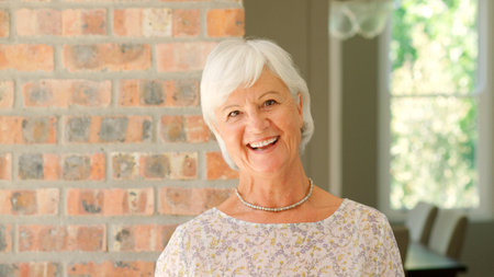 Head And Shoulders Portrait Of Smiling Senior Woman At Home