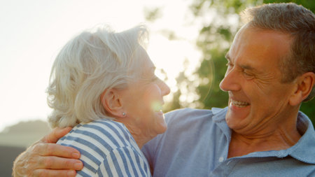Loving Senior Couple Outdoors In Summer Park With Lens Flare
